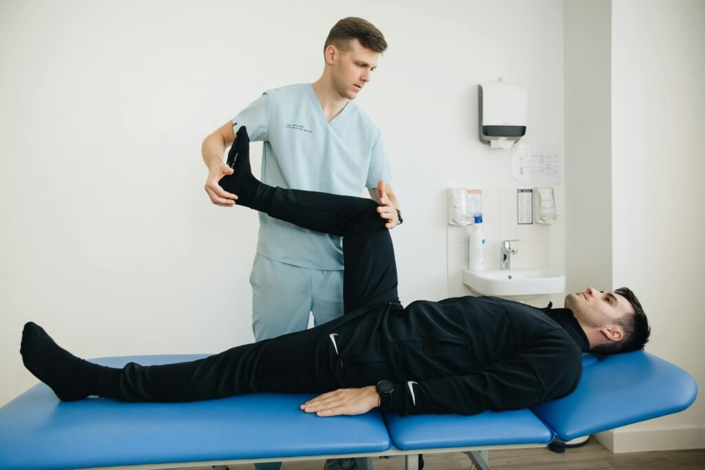 Physiotherapist helping a client with lower limb mobility rehabilitation in a modern clinic