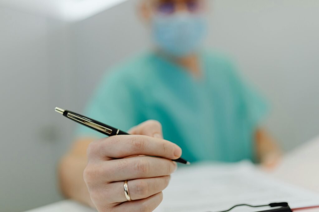 Close up of a physical therapist holding a pen over a clinical patient intake form during a consultation.