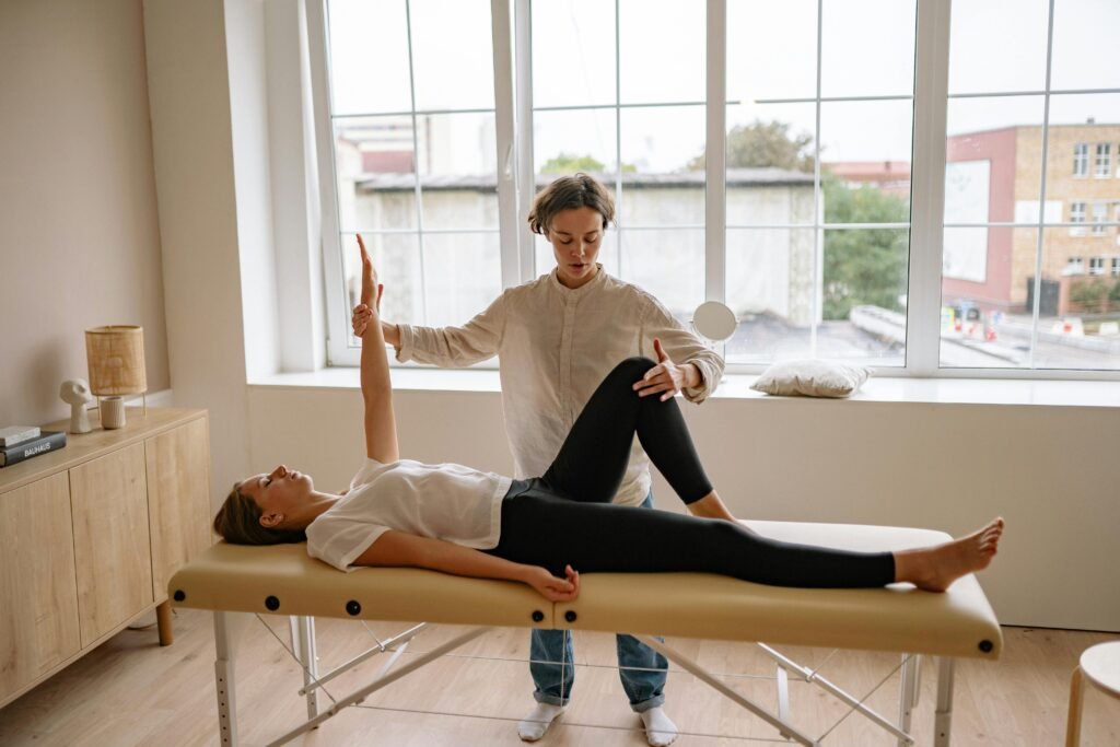 Professional physiotherapist assessing patient lower limb range of motion in bright clinic